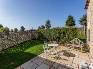 a patio with a table and chairs and a fence at Granary, Cheltenham in Cheltenham