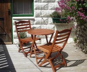 duas cadeiras de madeira e uma mesa e uma mesa e cadeiras em The Boathouse for two, St Davids, Garage Parking em St. Davids