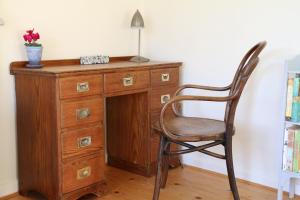 a wooden desk with a chair next to a dresser at The Boathouse for two, St Davids, Garage Parking in St. Davids