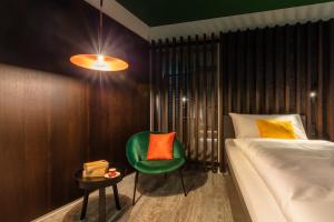 a bedroom with a bed and a green chair at Macardo Premium B&B 