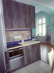 a kitchen with wooden cabinets and a stove top oven at Fiore in Duszniki Zdrój