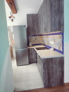 a kitchen with wooden cabinets and a stainless steel refrigerator at Fiore in Duszniki Zdrój