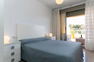 a bedroom with a blue bed and a large window at Big Terrace Apartment Cullera in Cullera +59 photos