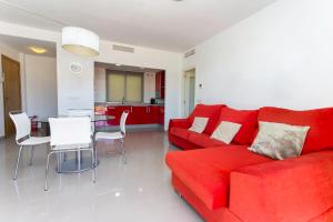 a living room with a red couch and a table at Big Terrace Apartment Cullera in Cullera