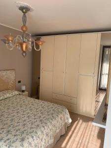 1 dormitorio con 1 cama y armario blanco grande en Appartamento Levico lake, en Levico Terme
