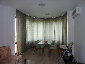 ein Wohnzimmer mit einem Tisch und Stühlen in der Unterkunft Riviera Sea VillageApartments Golden sands in Goldstrand