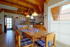 a kitchen and dining room with a wooden table and chairs at Strandvogt 2 NT13 in Dorum Neufeld +5 photos