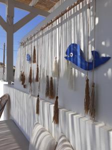 a porch with a blue fish hanging from a wall at Pontamos Villas in Halki
