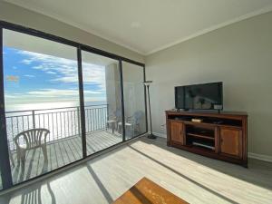 sala de estar con TV de pantalla plana y balcón en Ocean Forest Plaza by Palmetto Vacations, en Myrtle Beach
