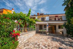 une maison avec une cour en brique ornée de fleurs et de plantes dans l'établissement Haus Roko, à Rovinj