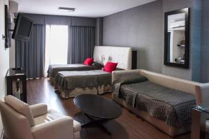 a hotel room with two beds and a couch at Ayres Recoleta Plaza in Buenos Aires