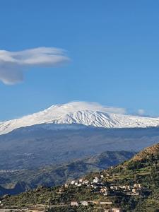 een vliegtuig vliegt over een besneeuwde berg bij Sciala' 2 in Taormina