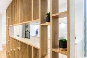 a room with wooden shelves and potted plants at ELEVEN Real de la Carretería, by Homing U in Seville