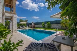 una piscina en un patio trasero con mesa y sillas en Volans Suites Villas, en Fethiye