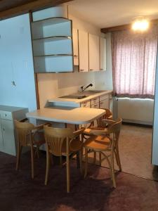 a kitchen with a table and chairs and a sink at Hotel Alpina in Unterwasser