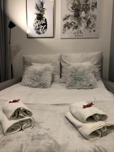Una cama blanca con toallas y almohadas. en Apartment Katowice Center, en Katowice