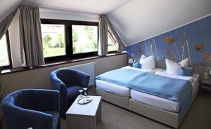 a bedroom with a bed and two chairs and a table at Zum Alten Hafen in Rathenow
