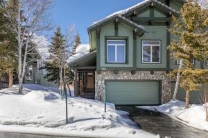 a green house with a garage in the snow at Snowcreek V 733 in Mammoth Lakes
