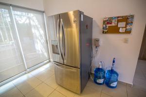 プエルト・モレロスにあるCasa Pakalの- キッチン(ステンレス製の冷蔵庫、ボトル入り飲料水2本付)