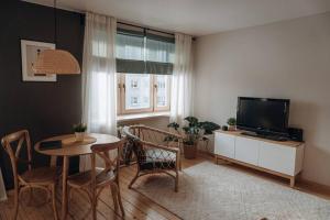 Una sala de estar con una mesa y un televisor. en Teatra street apartment, en Balvi