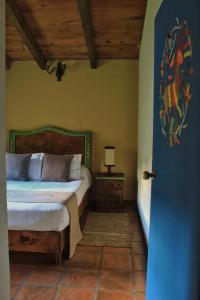 a bedroom with a bed and a table with a lamp at Spa Holistico Real Hotel in Mineral del Monte