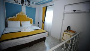 a bedroom with a bed with a yellow and white bedspread at TAKSIM MAYA HOTEL in Istanbul