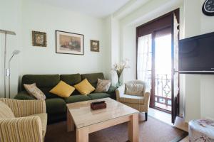 a living room with a green couch and a table at "KM CERO DE SEVILLA" in Seville