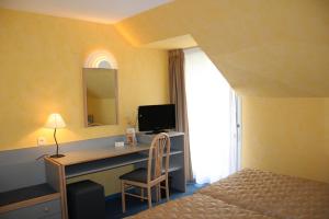 1 dormitorio con escritorio, ordenador y cama en Au Relais de l'Oust, en Josselin