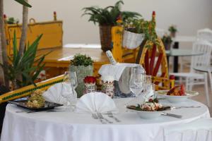 a white table with plates of food on it at Agriturismo Resort Costa House in Lampedusa