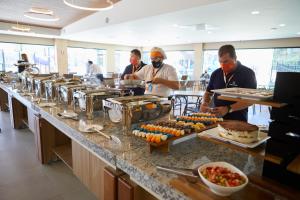 un grupo de chefs que preparan comida en una cocina en Praias do Lago Eco Resort by WAM Experience, en Caldas Novas