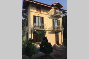 a large yellow building with balconies on it at Luminoso appartamento in Villa a Stresa in Stresa +5 photos