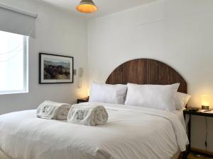a bedroom with a large white bed with towels on it at Ayacucho apartments near Huaca Pucllana in Lima