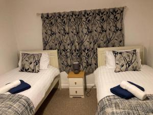 a bedroom with two beds with towels on them at Holcot Cottage 