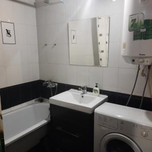 a bathroom with a sink and a washing machine at Apartment on Plekhanovskaya street 22 in Voronezh