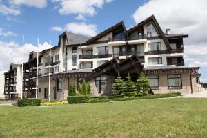 a large building with a grass field in front of it at Aspen Golf and Ski Resort in Bansko