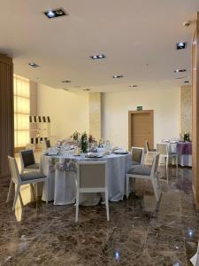a dining room with tables and chairs with white tablecloths at Gran Hotel Don Manuel in Cáceres