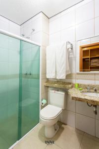 a bathroom with a toilet and a glass shower at VOA Express Inn Hotel Orquídea in Várzea Paulista