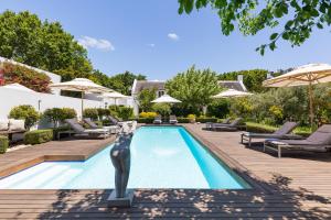a statue of a woman standing next to a swimming pool at Maison Cabrière - Boutique Suites in Franschhoek
