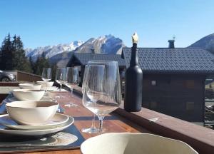 a table with glasses and plates and a bottle of wine at La Belle Etoile in Manigod