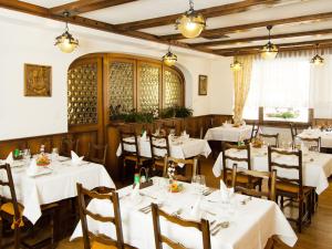 a restaurant with tables and chairs with white tablecloths at Hotel Monte-Moro in Saas-Almagell