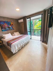1 dormitorio con cama y ventana grande en Recantos do Dende, en Itacaré