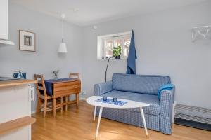 sala de estar con sofá azul y mesa en Ljungs Fem Rum, en Västergarn