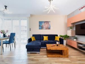 a living room with a blue couch and a table at Apartament Porto Santa Rewales in Rewal