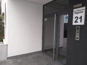 una puerta de cristal de un edificio con un cartel en Apartament 5k Nautica Szczecin en Szczecin