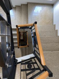 un conjunto de escaleras con barandilla de madera en Hotel Condes De Lemos España, en Monforte de Lemos