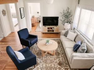 a living room with a couch and two chairs and a television at Revived Schoolhouse near Downtown and UT Campus in Knoxville