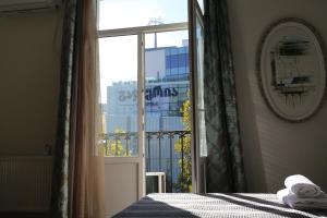 1 dormitorio con ventana y vistas a un edificio en Piano Foyer Apartments at City Center en Tiflis