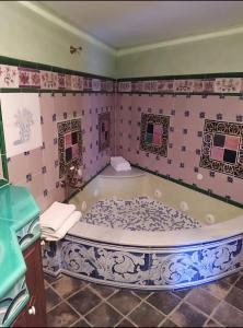 een badkamer met een groot bad in een kamer bij A la Sombra de la Torre in Serra