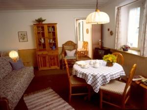 a living room with a table and a couch at Maiergschwendter-Hof in Ruhpolding