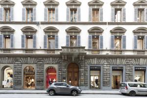 deux voitures garées devant un bâtiment avec fenêtres dans l'établissement B&B Prestigia Rooms, à Florence